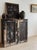 A substantial English pine cupboard with a richly layered, chippy black painted finish worn back to reveal warm undertones...