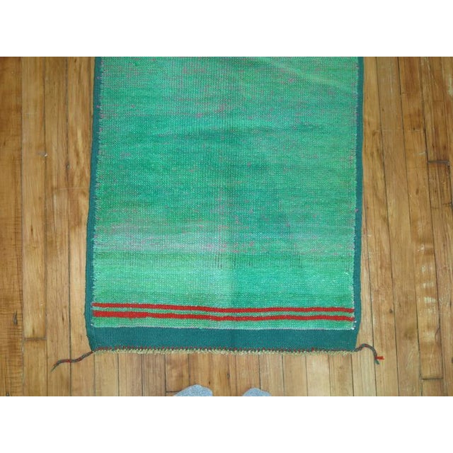 One of our most interesting finds recently this eclectic one of a kind vintage Anatolian with a plain solid green field...