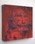 The artwork depicts a stylized representation of a wild animal's head, rendered in bold reds and deep blues that evoke a...