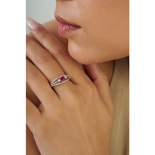 This split shank ring features a 0.42 carat natural ruby set in 14K white gold. The ruby measuring approximately 4.8 x 3.8...