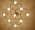 Architectonic flush light featuring a four leaves clover shaped arrangement of 9 intertwined spokes , all gilded brass...