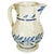 A charming 19th-century earthenware pitcher, hand-decorated with stylized floral motifs in cobalt blue tones on a creamy...