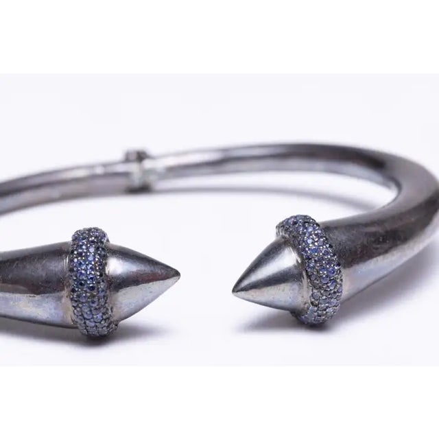 A hinged cuff bracelet in oxidized sterling silver with pave`-set, round brilliant cut sapphires at the top. Insider...
