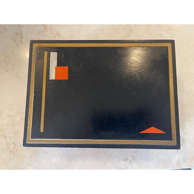 A rectangular box with hand-painted geometric design details in an array of colors. Hinged lid. c. 1930s. Some...