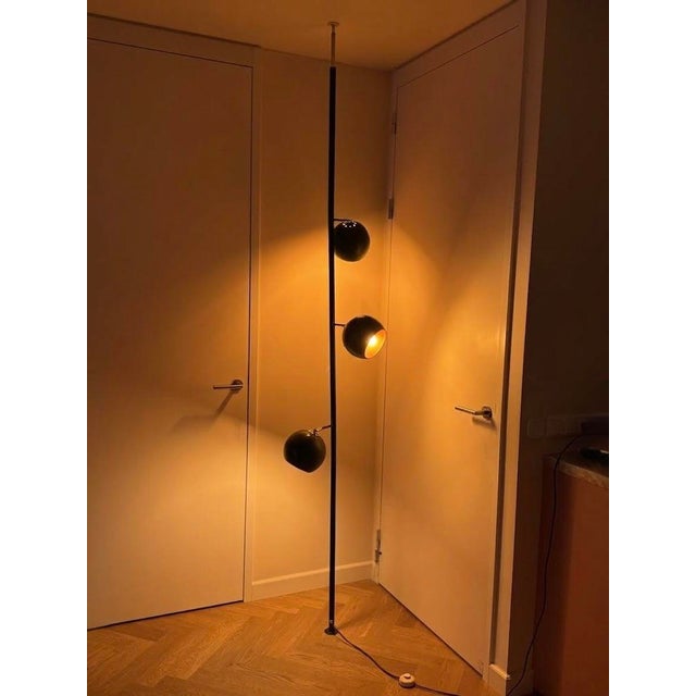 A real statement piece, this dark green tension pole lamp features three adjustable "eyeball" spotlights. The lamp spans...