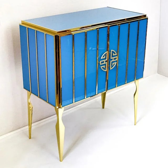 Sideboard with two doors, entirely handmade, with wooden structure and surface finishes in blue Murano glass; profiles,...