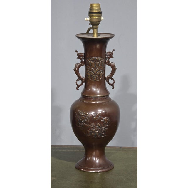 A very good pair of Japanese bronze table lamps with dragon handles, blossom relief to the fronts, in very good condition,...