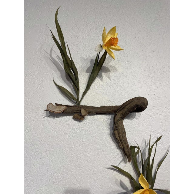 Catch My Drift II features a harmonious blend of natural elements, incorporating organic forms and vibrant yellow flowers...