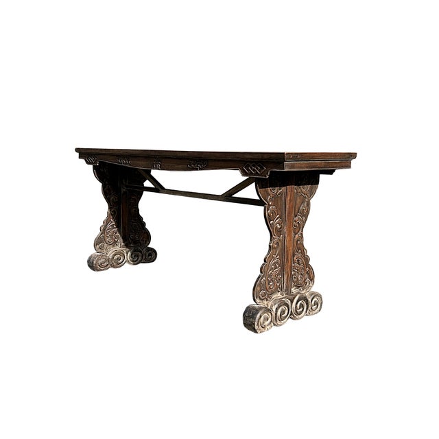 This antique altar table is a striking example of traditional craftsmanship, characterized by its deep, weathered wood and...