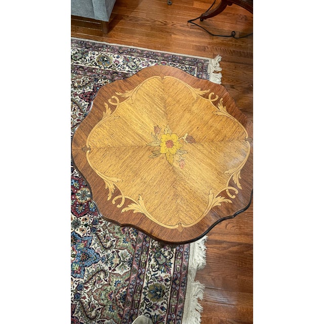 This restored elegant occasional table is inlayed with a central floral marquetry medallion, framed by scrolling foliate...