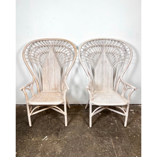 Vintage pair of rattan fan back arm chairs. Tall back chairs with pencil reed detail. Removable cushions with woven seats....