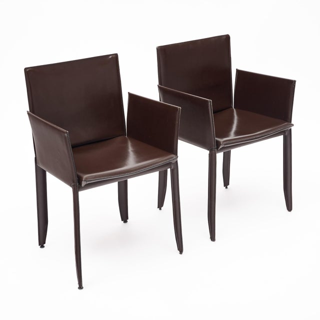 Italian leather armchairs in the manner of Poltrona Frau, featuring elegant saddle-leather construction with fully wrapped...