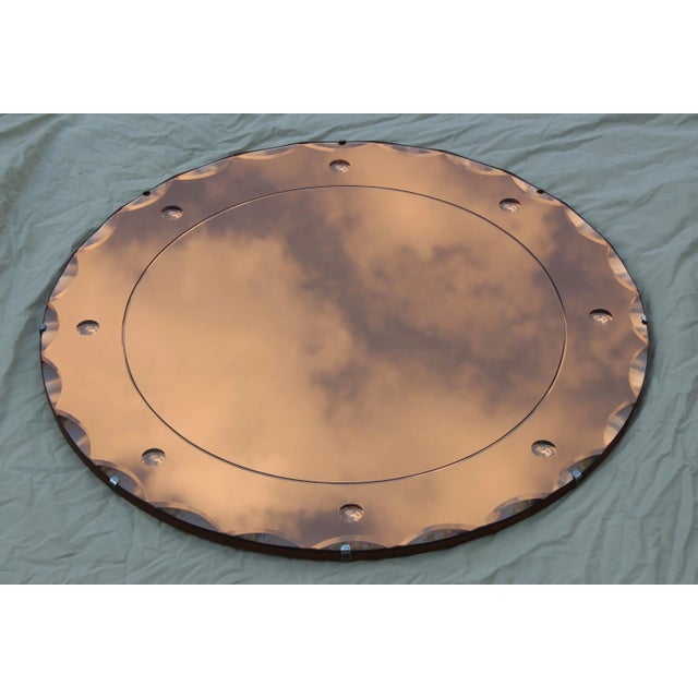 1950s modern peach colored French wall mirror, with wood back and chrome detail.