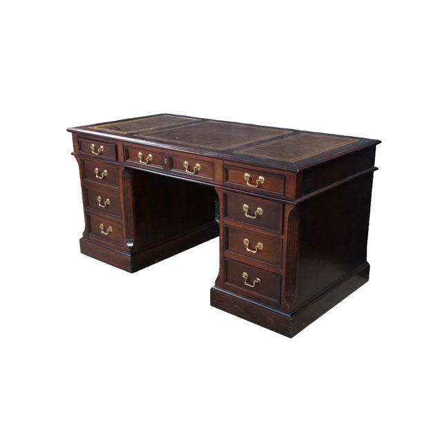 Vintage Hekman Mahogany kneehole executive desk featuring a three panel inlaid tooled leather top with gold accents. The...