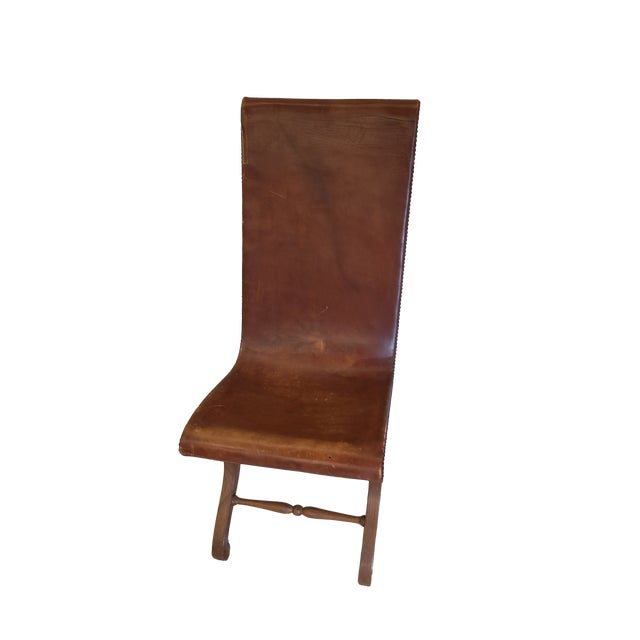 This is a beautiful set of chair and ottoman from the Spanish style of Pierre Lottier. The leather is distressed but that...