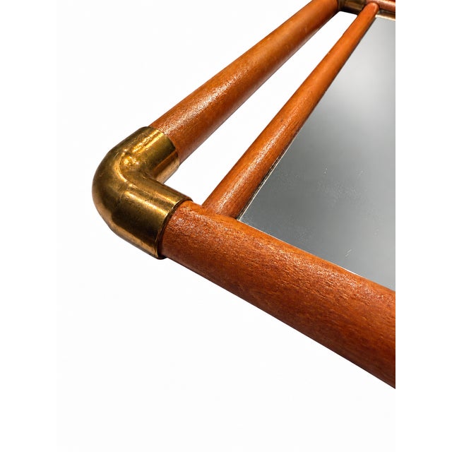 Rectangular mirror featuring a warm-toned solid wood frame with brass corner fittings. Good pre-owned condition with...
