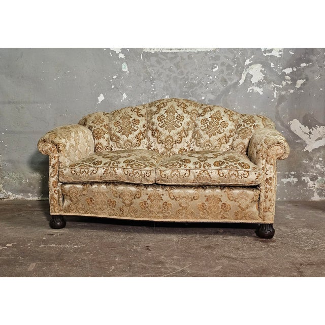 Elegant two-seater sofa with original floral silk velvet upholstery. The distinctive leg is typical of the English...