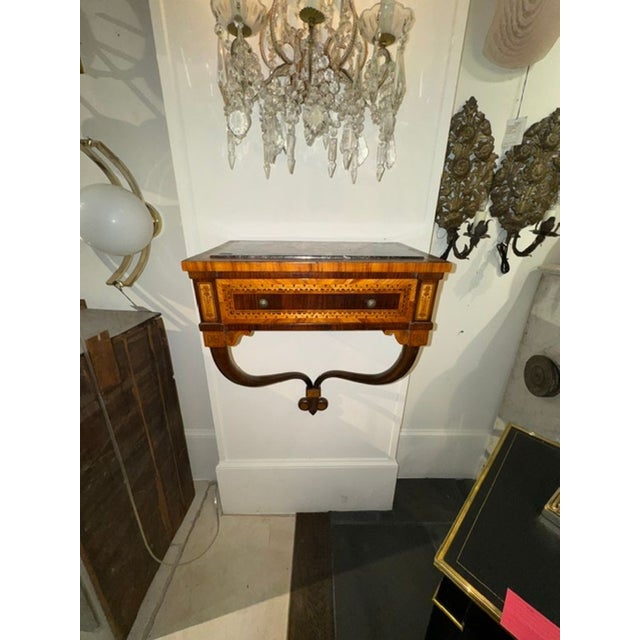 The product is a 19th century Italian inlaid mahogany wall console, featuring intricate designs and craftsmanship. This...