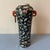 Vintage Asian style Famille Noir vase with lots of flowers, orange handles, and a gold ring hanging off one handle.