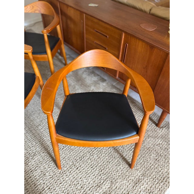 Iconic solid teak chairs with black leather seats in the style of Hans Wegner, circa 1960s(?). There are three available....