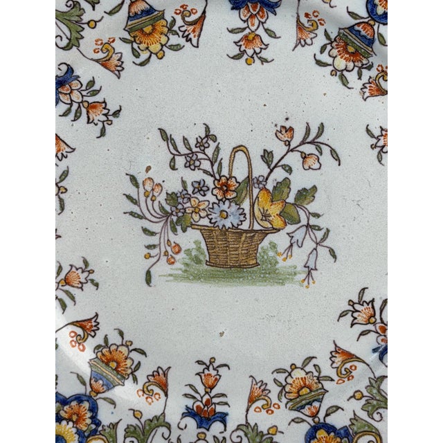 Decorative pair of antique French faience plates dating to the late 18th – early 19th century, painted in the traditional...