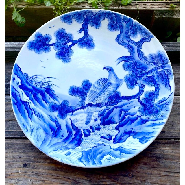 An exceptional large-scale Japanese blue and white porcelain charger featuring a majestic hawk perched among ancient pines...