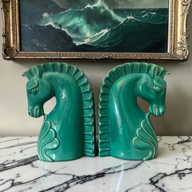 A striking pair of oversized turquoise glazed ceramic horse bookends showcasing bold Art Deco-inspired design and...