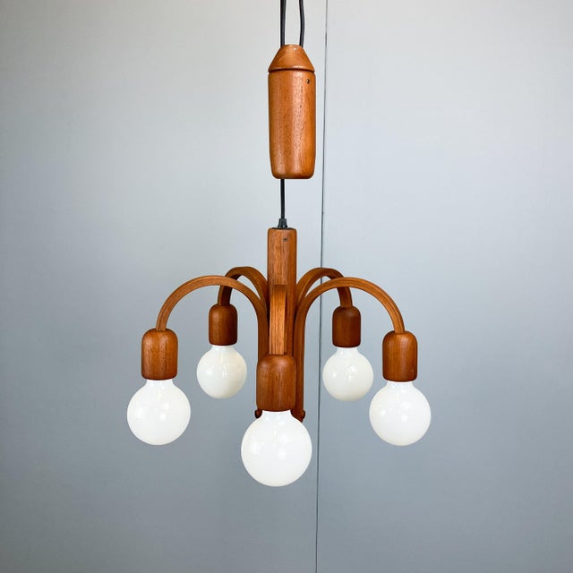 A beautifully crafted lamp made of solid teak with adjustable height. This lamp combines scandinavian mid-century...