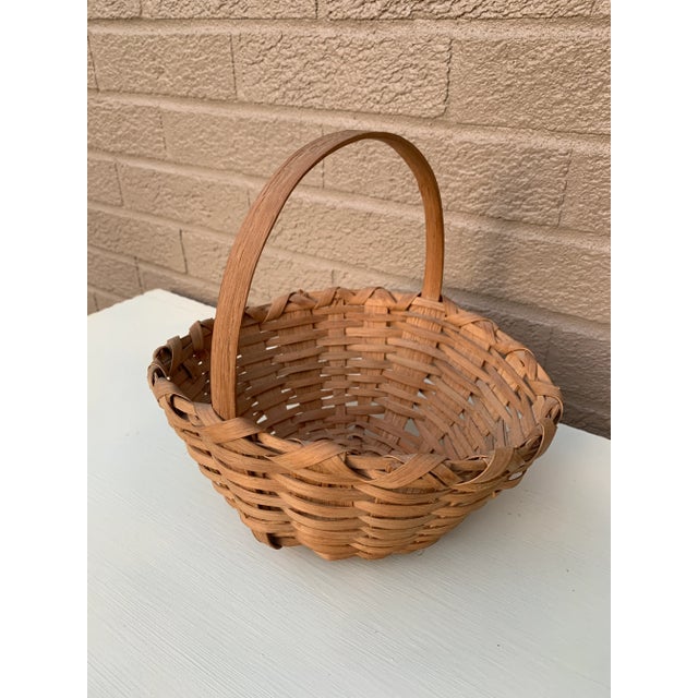 A beautifully woven early 20th century American splint oak basket with warm honeyed tones and a tightly constructed...