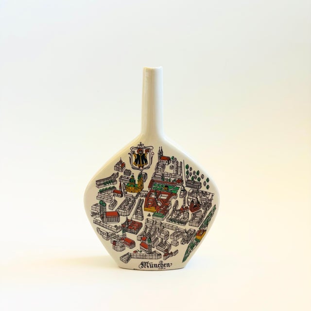 A mid century German ceramic bottle vase designed by Anton Riemerschmid. Glossy white base glaze with a colorful rendering...