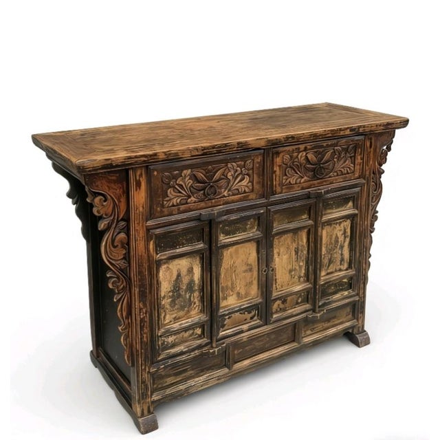 This antique elm sideboard features 2 upper drawers detailed with deep, hand-carved floral and leaf motifs and circular...