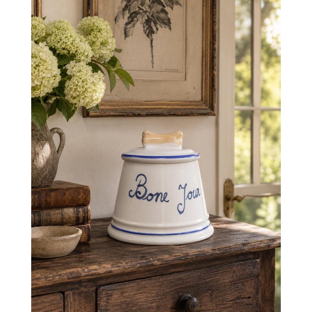 A charming late-20th-century French Country dog-treat canister crafted from white glazed porcelain with hand-painted...