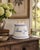 A charming late-20th-century French Country dog-treat canister crafted from white glazed porcelain with hand-painted...