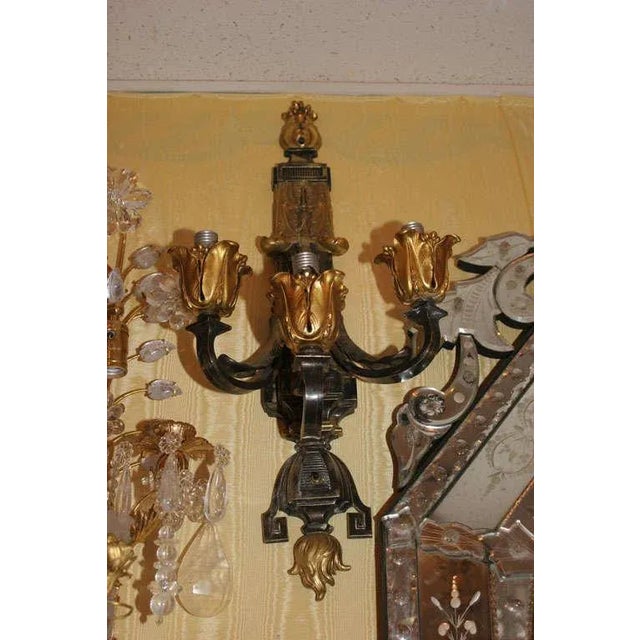 Fabulous two-toned patinated and gilt bronze three-arm wall sconces in the Caldwell style.