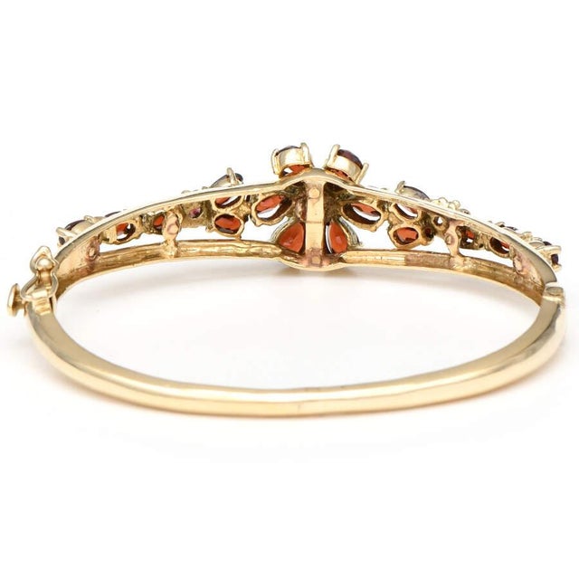 Cranberry-colored garnets are delicious to behold as they cluster on this breathtaking vintage bangle bracelet. A yellow...