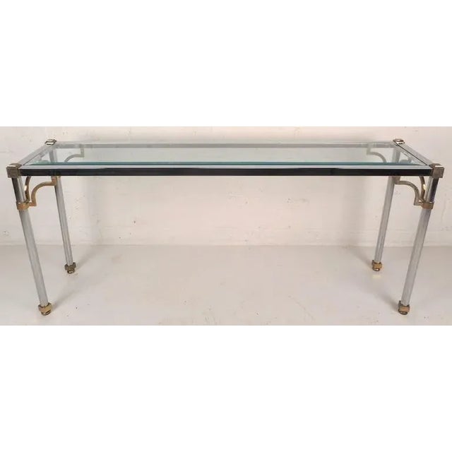 This stunning vintage modern console table features a heavy chrome frame with brass accents on each corner and on all four...