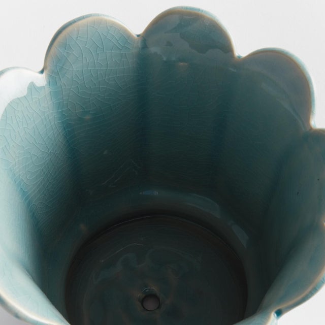 In a classic silhouette with petal edges, this footed pot is natureinspired. Finished in a soft sage reactive glaze, it is...