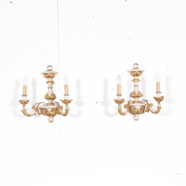 A beautiful pair of vintage 20th century hand carved wooden Italian painted and parcel gilt two-light sconces, circa...