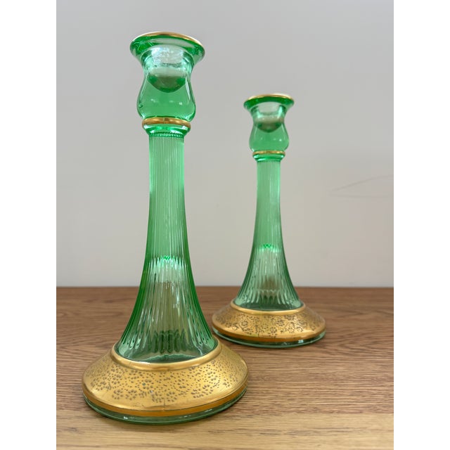 These green ribbed glass candlestick holders feature gold accents and a beautifully detailed stippled base. They are...
