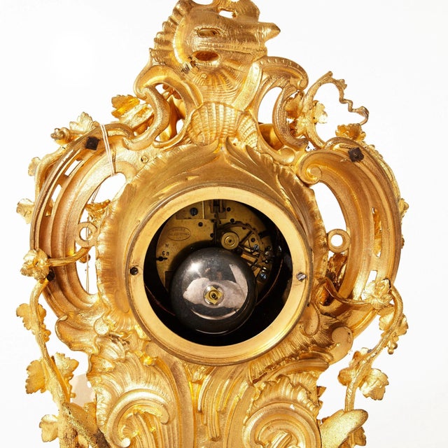 Mantel clock in gilded bronze in Louis XV style, richly decorated with decorative elements with figures of playing Putti....