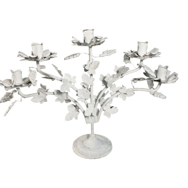 A vintage tole candelabra. Five arms covered in vine leaves and clusters of grapes. Each arm has a candle holder made of...