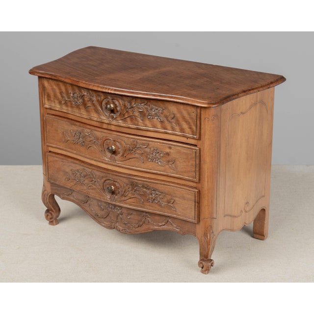 A Louis XV style French miniature sample chest made of solid walnut with serpentine front and three dovetailed drawers....