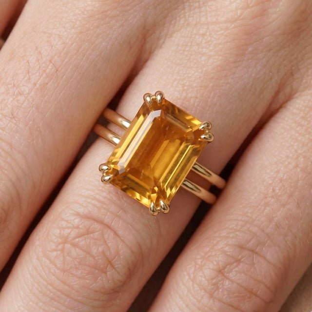 This exquisite ring features a radiant Citrine gemstone, prized for its warm, golden-yellow tones and sun-kissed...