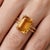 This exquisite ring features a radiant Citrine gemstone, prized for its warm, golden-yellow tones and sun-kissed...