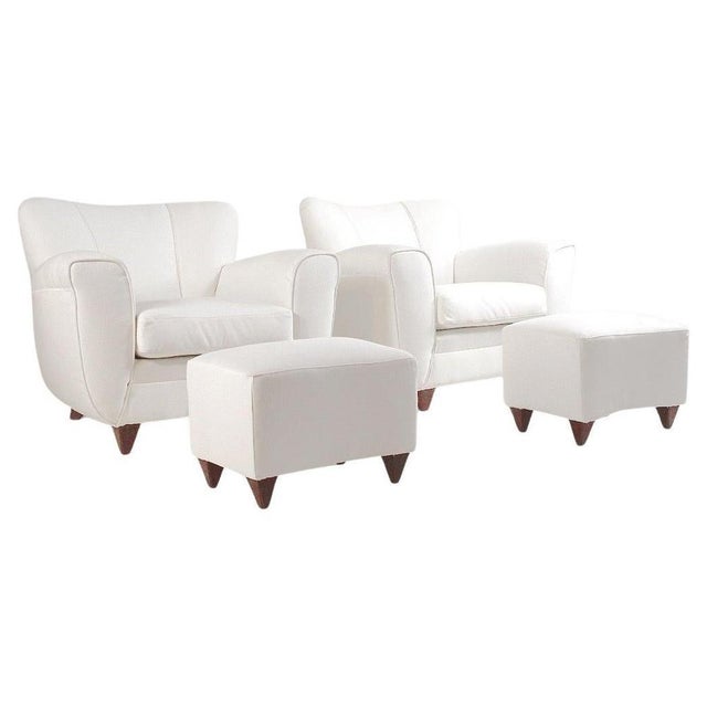 Pair of armchairs with foot stools in white fabric, Italian production from the 1940s. Structure and feet in the shape of...