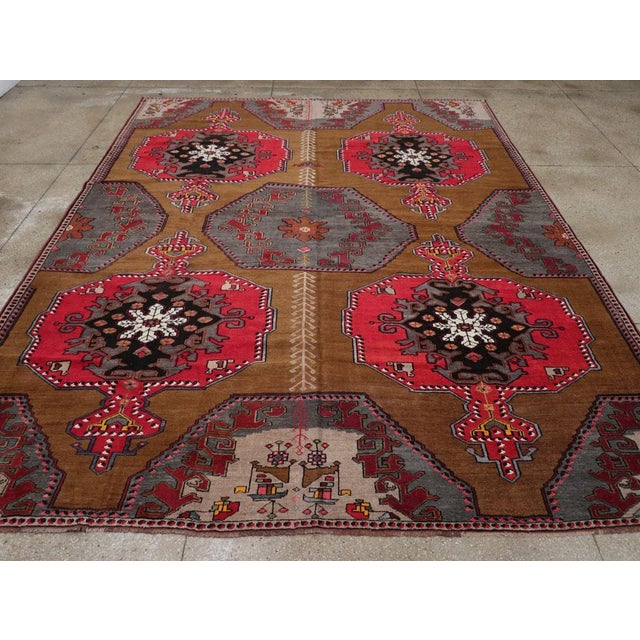 A wool pile of symmetric knots on a wool foundation. This striking rustic carpet shows a rust-red field with a decoration...