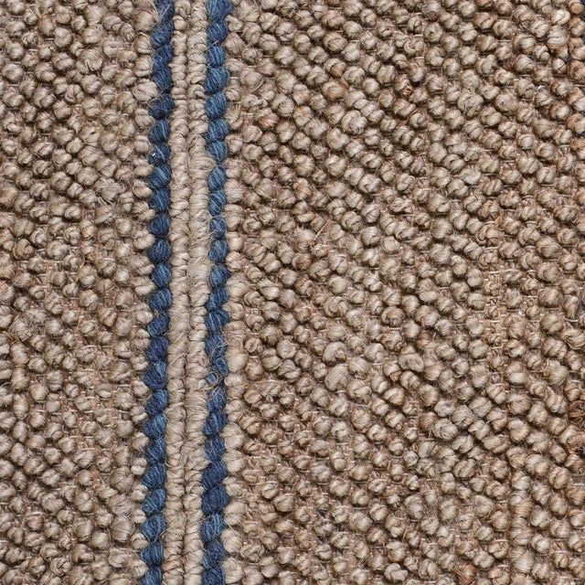Hand woven natural jute rug with navy striped detail. Please note that its appearance may vary depending on lighting...