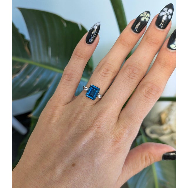 A generous 4.01-carat London blue topaz glows in deep, oceanic blue at the centre of this solid 10K yellow gold estate...