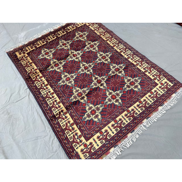 A vintage Afghan Turkmen tribal rug in an uncommon ivory-dominant colorway — a bold cream diamond lattice grids the field,...