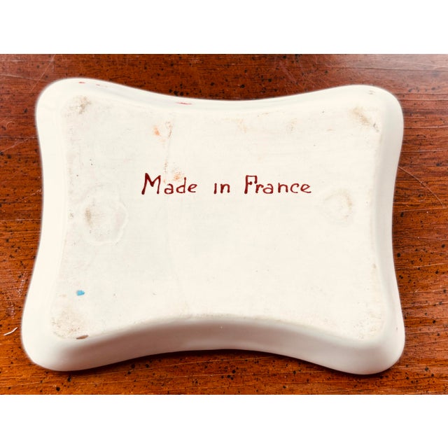 A delightful vintage French porcelain catchall featuring the hand-painted phrase: “Qui va doucement va sûrement.” The...
